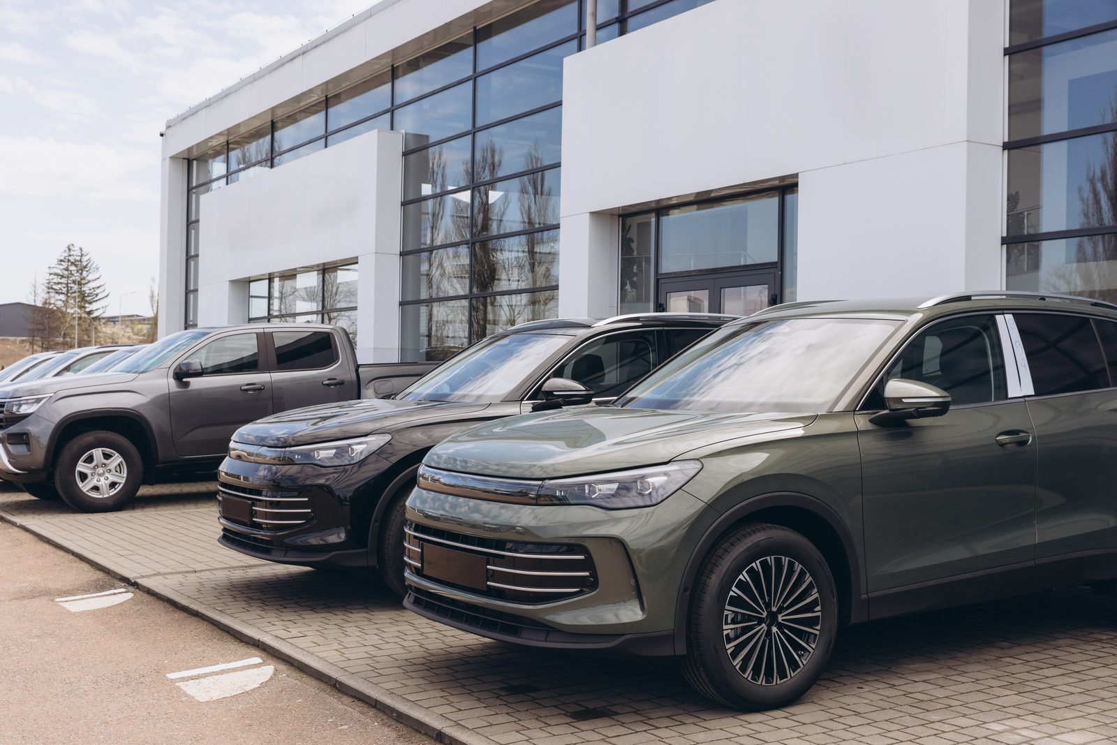 Modern car dealership exterior with multiple vehicles — multi-location operations